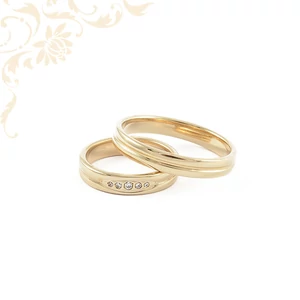 14K sárga arany karikagyűrű pár. A női gyűrű öt berakott cirkónia kővel díszített, míg a férfi gyűrű sima, ívelt kivitelű, a végtelen szeretet szimbóluma