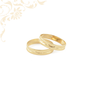 Arany karikagyűrű pár, gyémántvésett mintával díszítve.